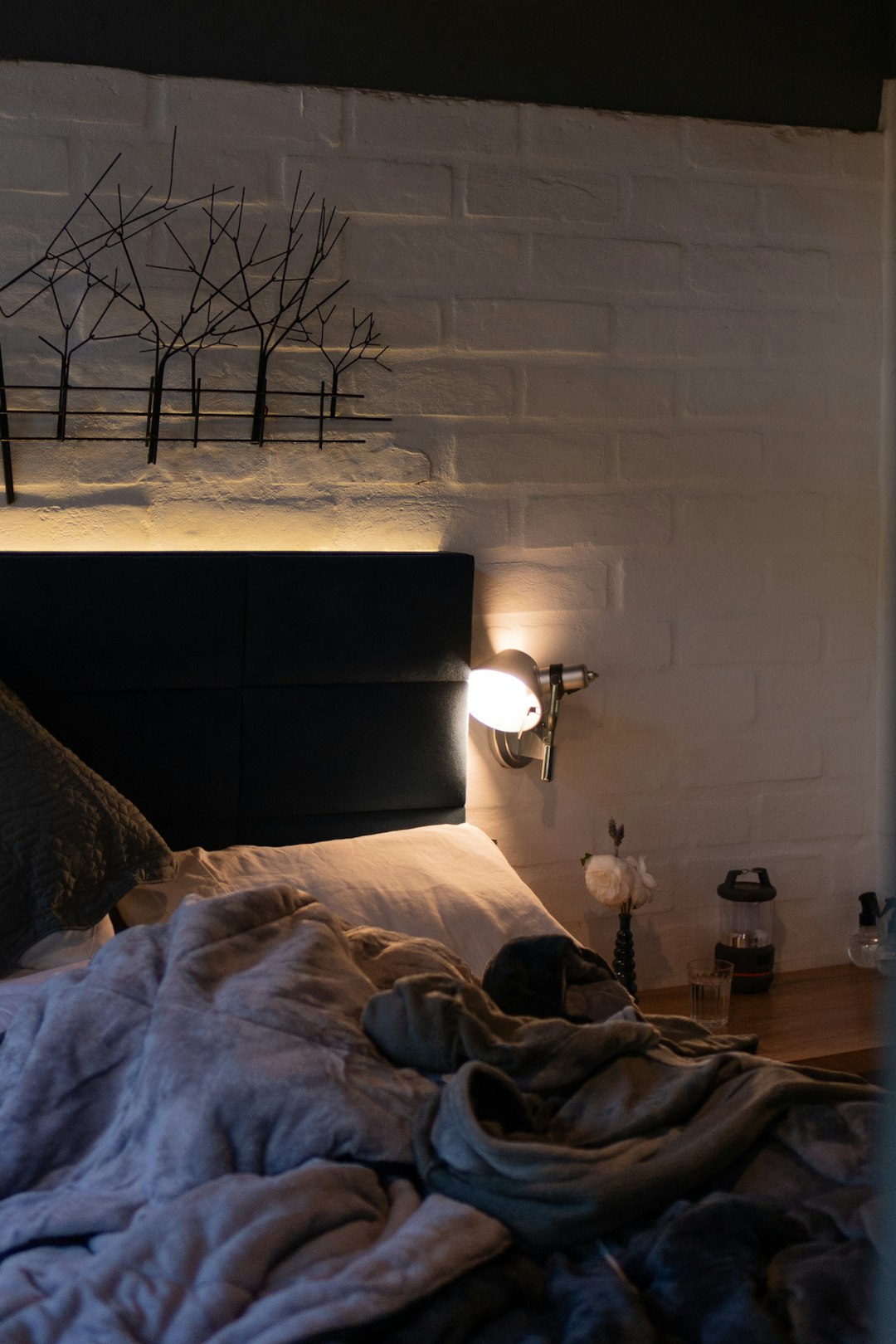 Cozy winter bedroom corner with knit throw, candle, and steaming mug