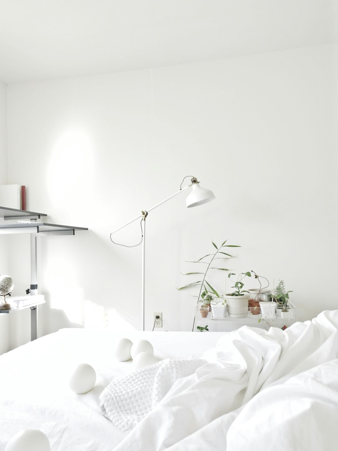 Dreamy minimalist white bedroom with linen bedding and morning sunlight