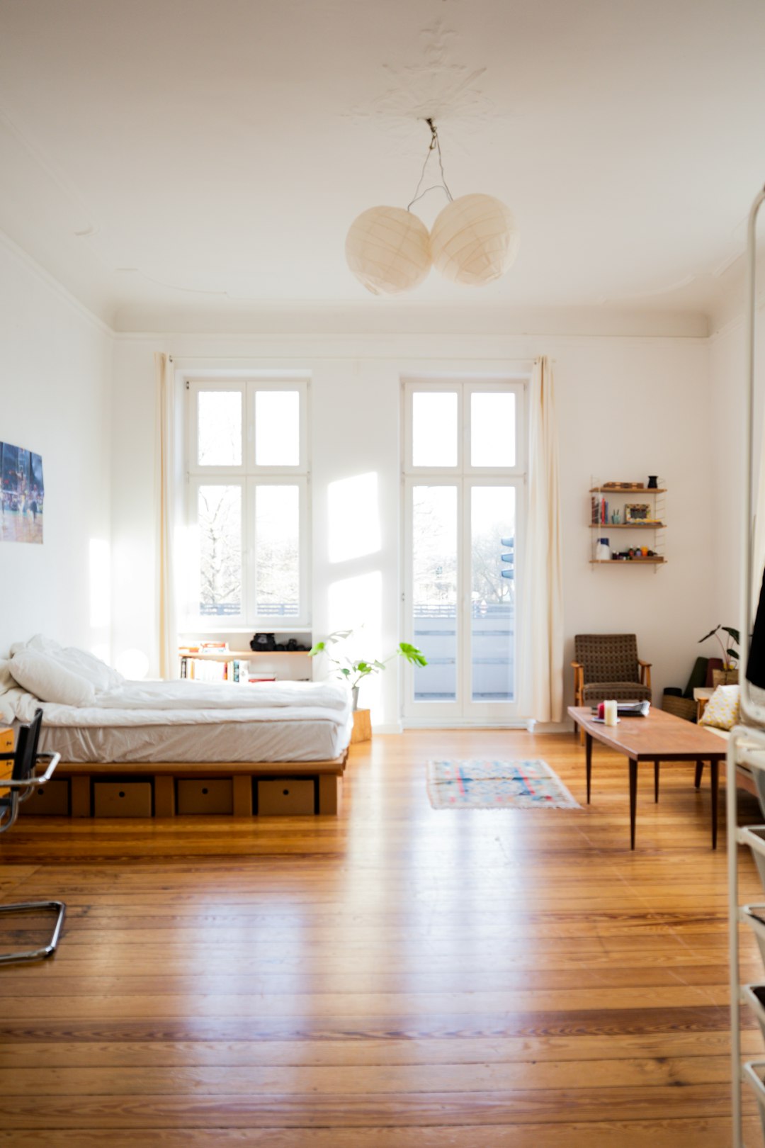 Dreamy studio apartment bedroom zone with sage curtains and golden hour light