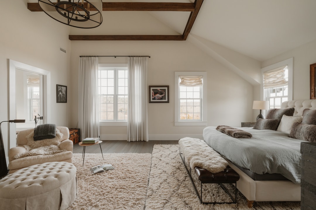 Master bedroom with sage armchairs and sitting nook near sunlit window
