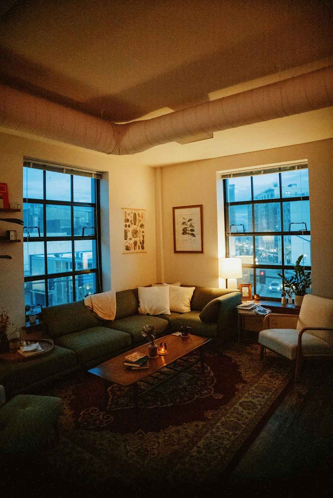 Bright windowless living room styled with warm layered lighting and mirrors