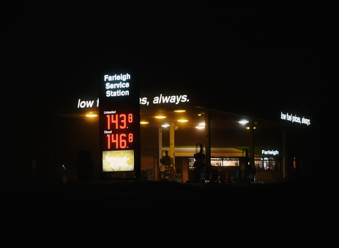 Busy gas station at dusk with price sign