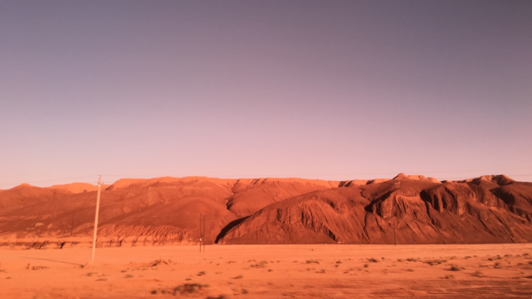 Mars rover on red rocky terrain at dusk