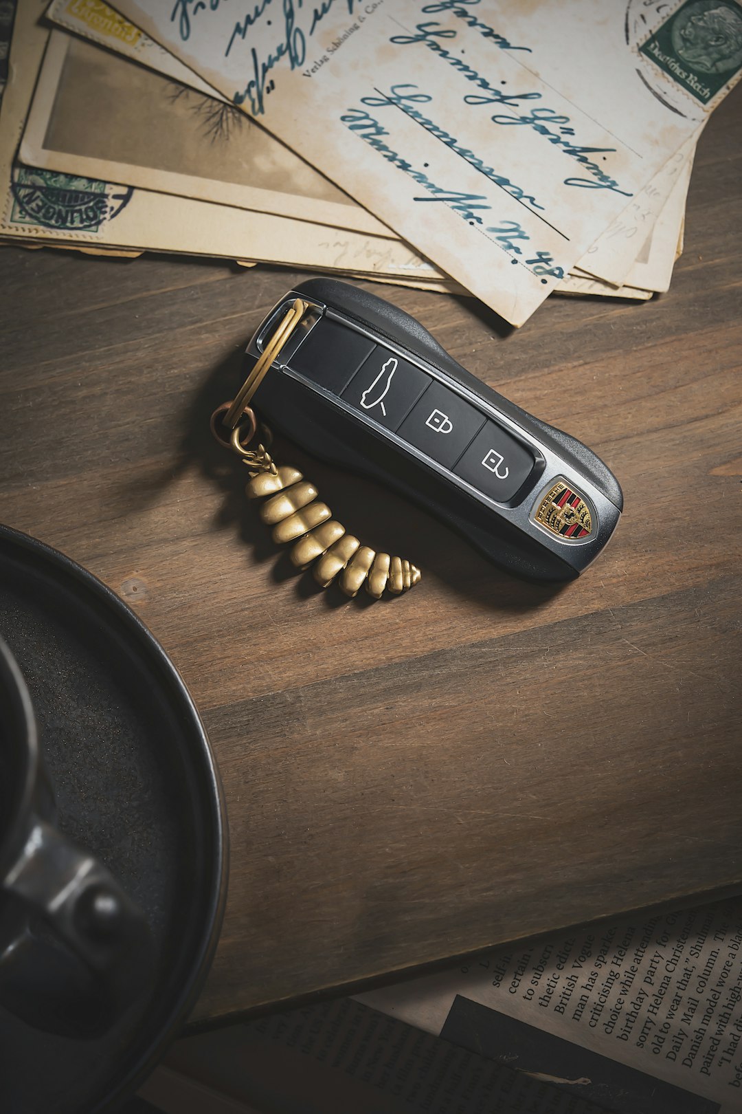 Car key beside financial document on wood surface