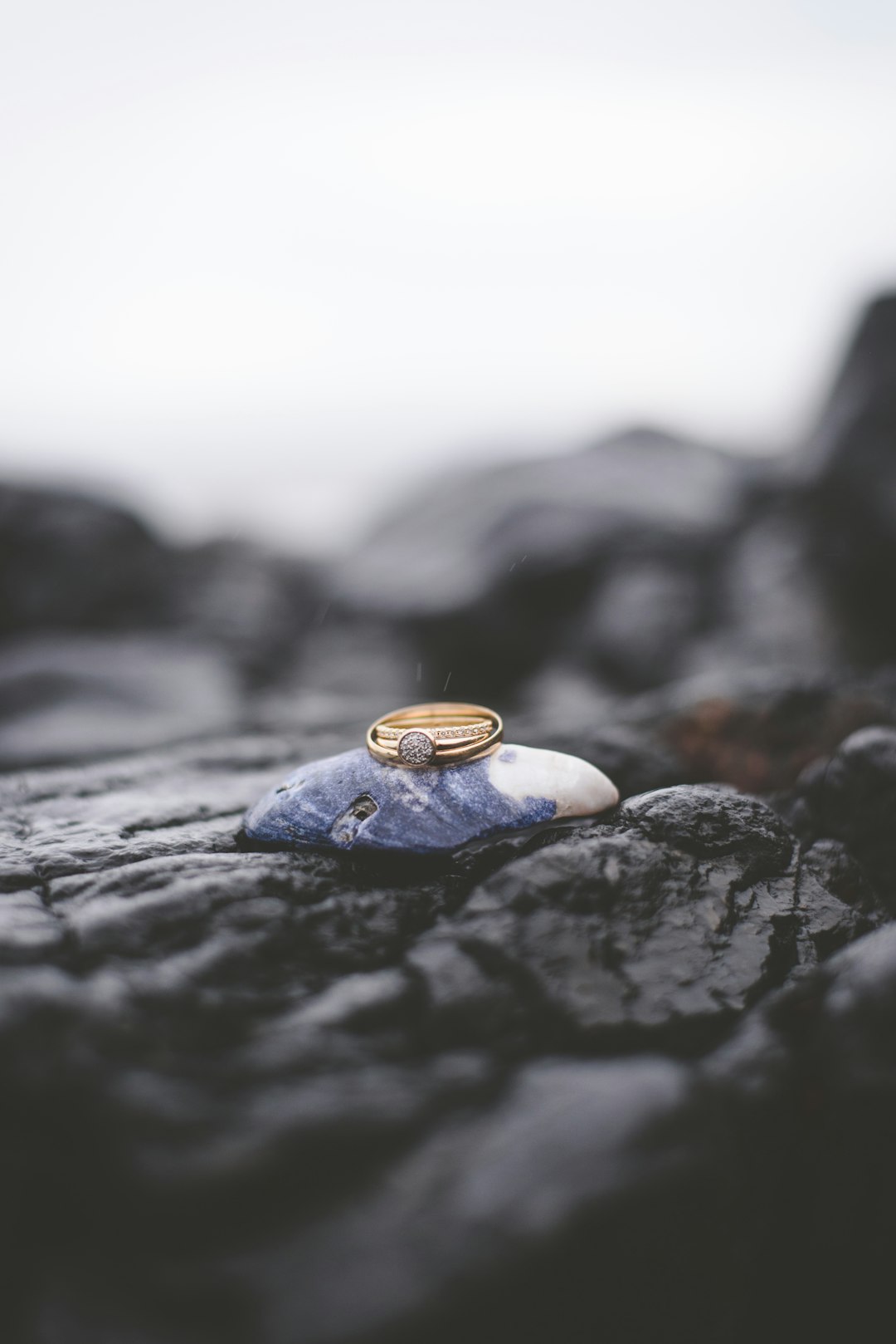 Single gold ring standing on dark stone surface