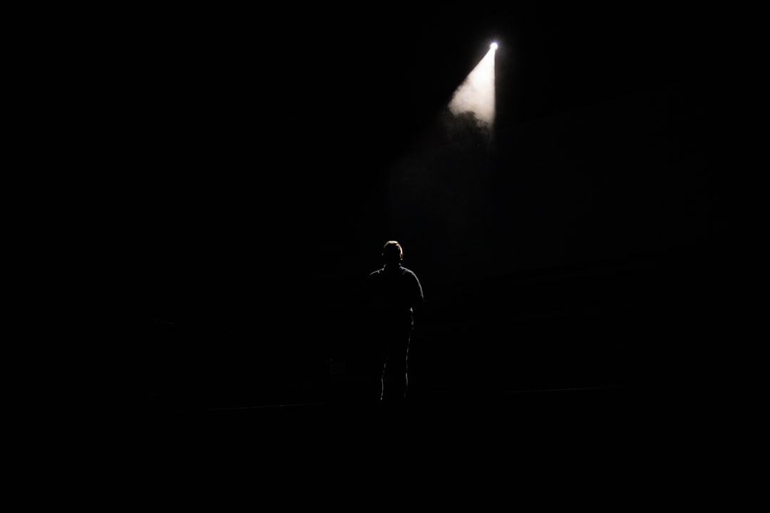 Silhouette of person facing glowing search bar screen