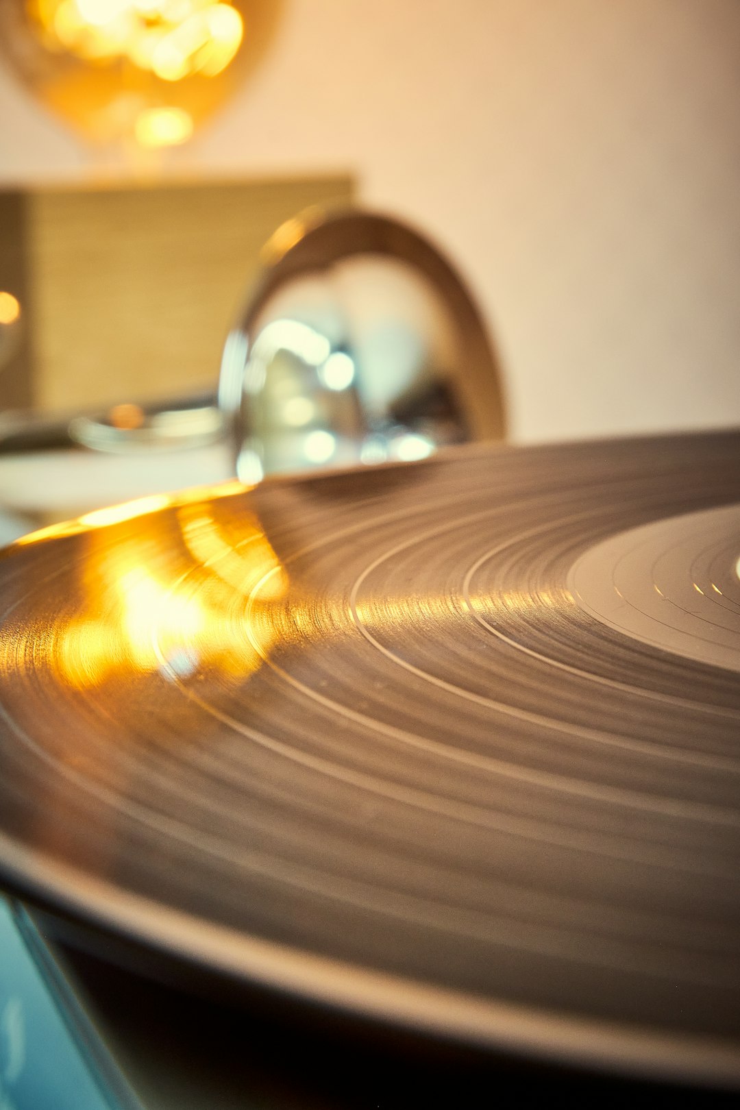 Disco de vinilo girando en tocadiscos con luz cálida
