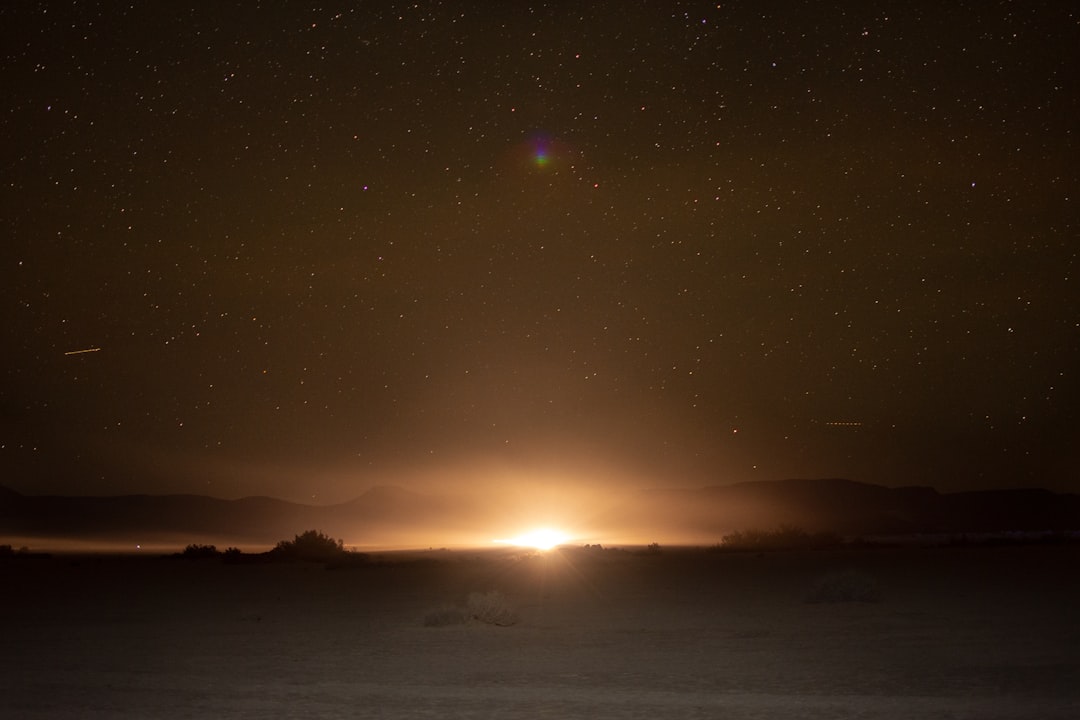Full moon rising over desert horizon at night