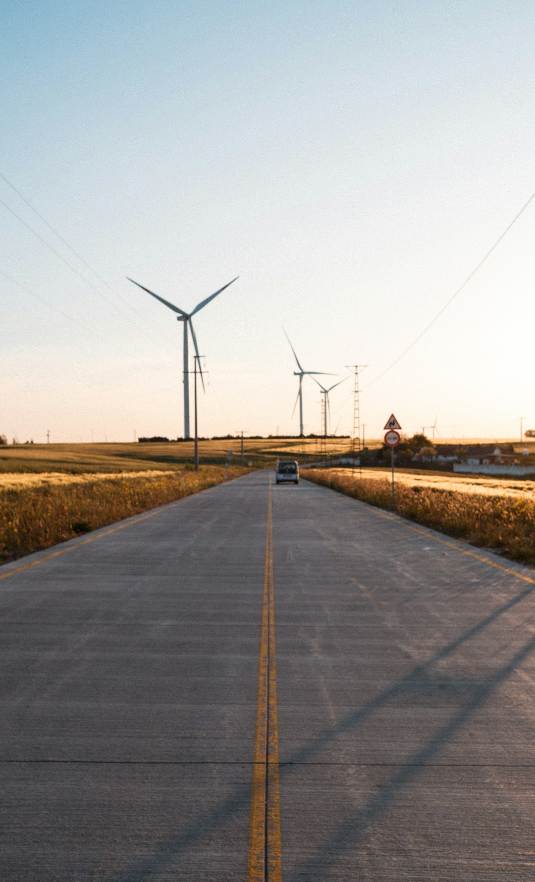 Voiture électrique seule sur route déserte au coucher du soleil