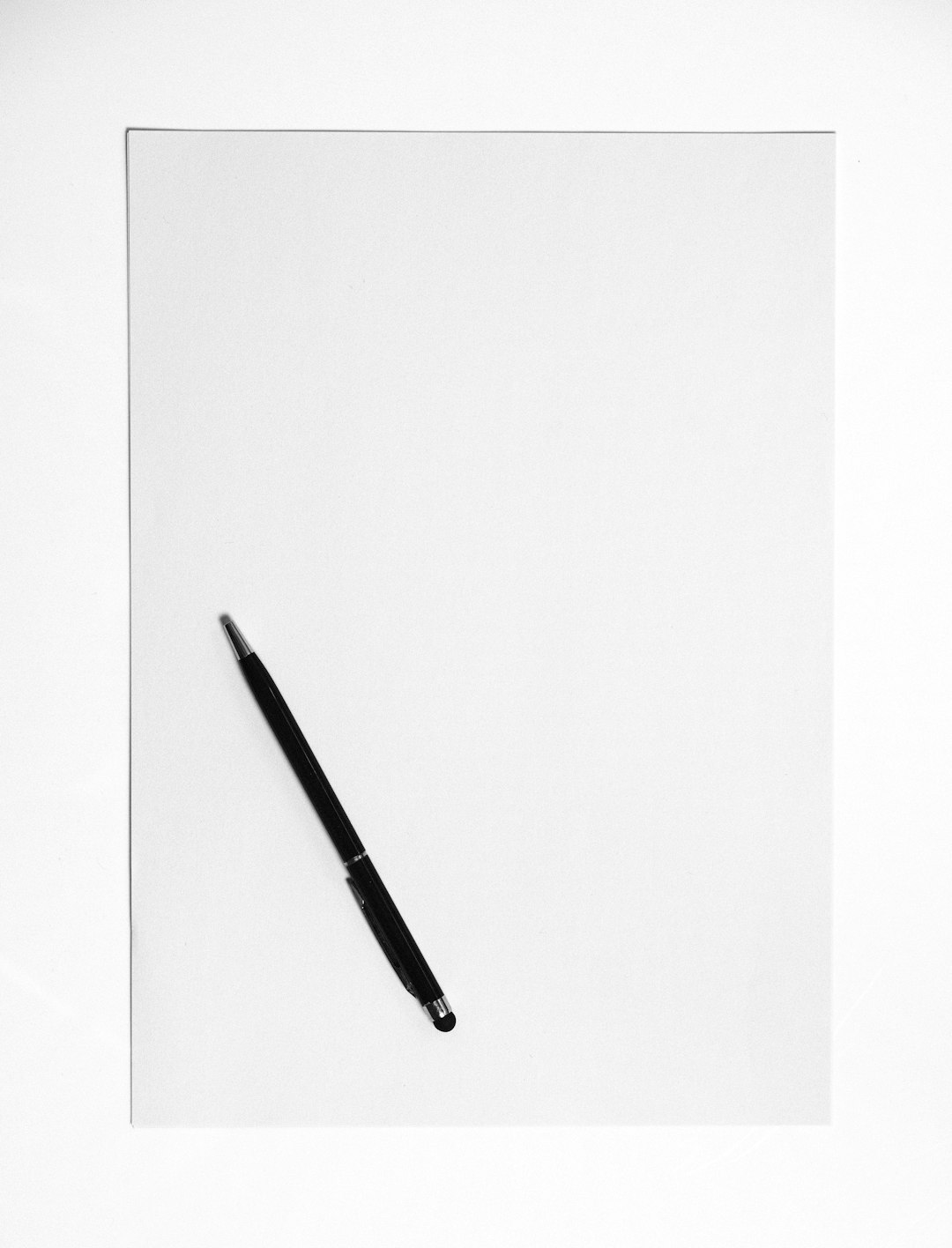 Open business plan document with pen on white desk