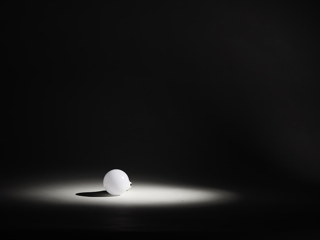 Single numbered ping-pong ball under dramatic spotlight