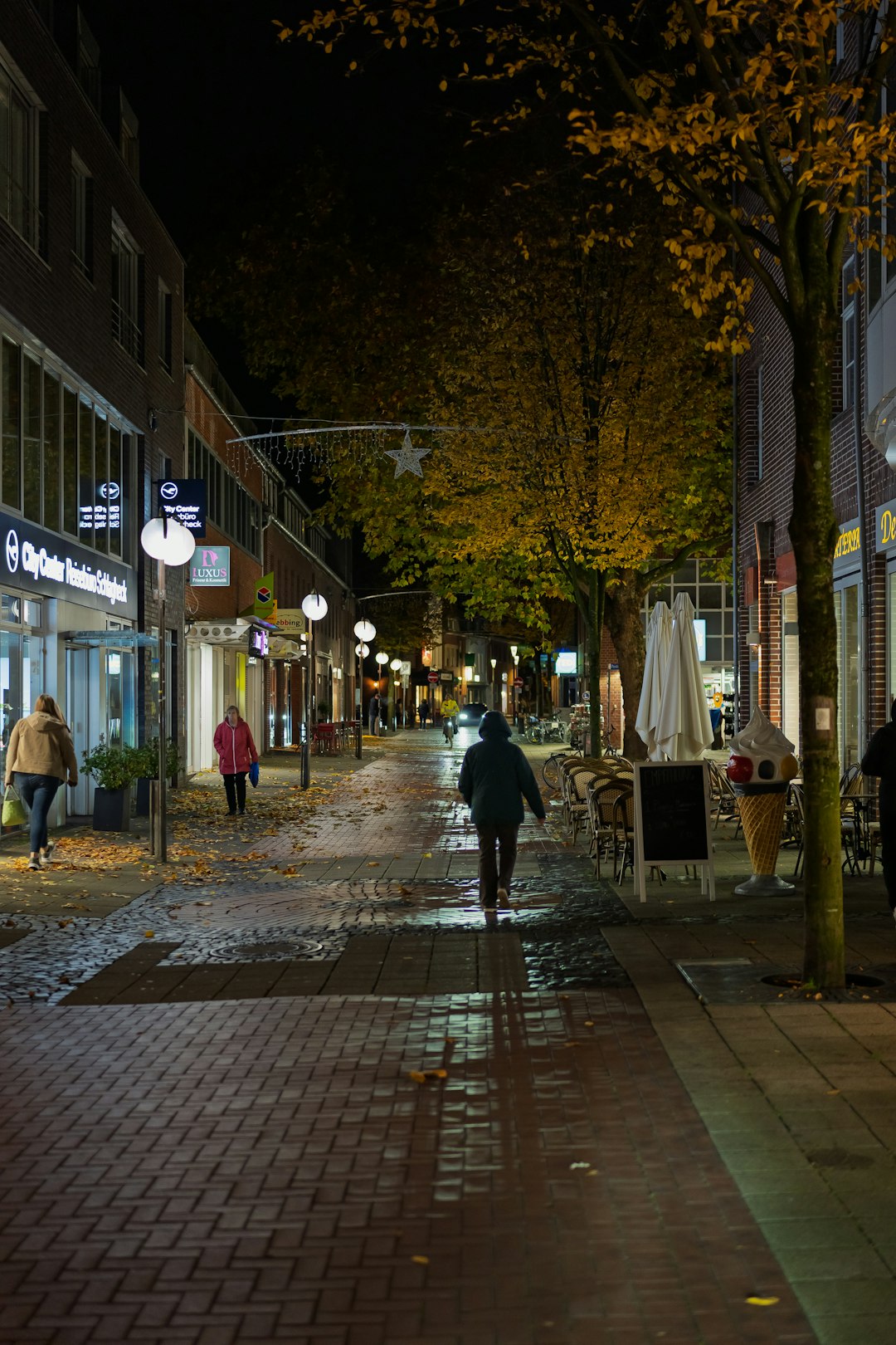 Pessoa com fones de ouvido caminhando à noite na cidade