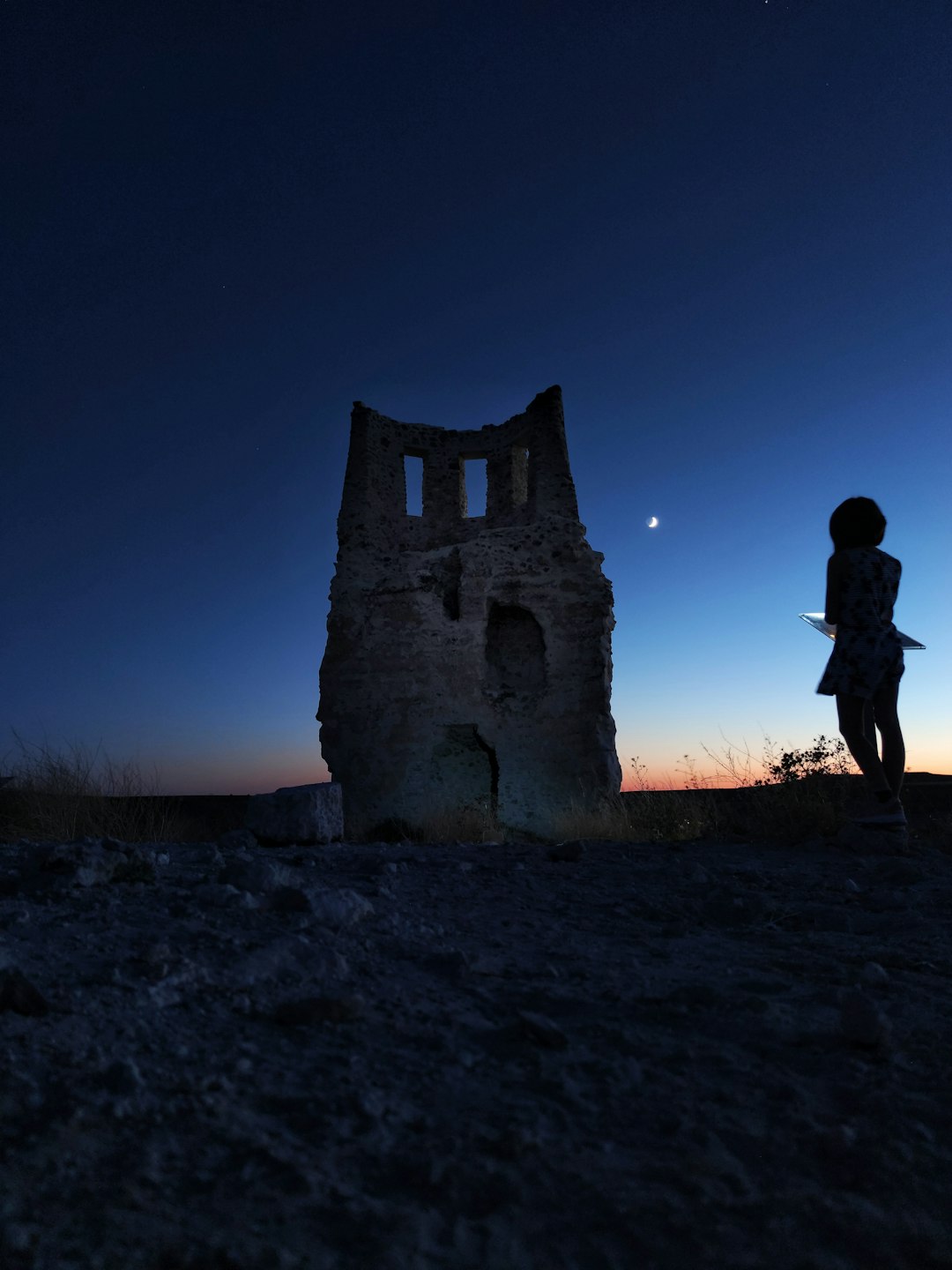 Vollmond hinter altem Steinturm in der Abenddämmerung