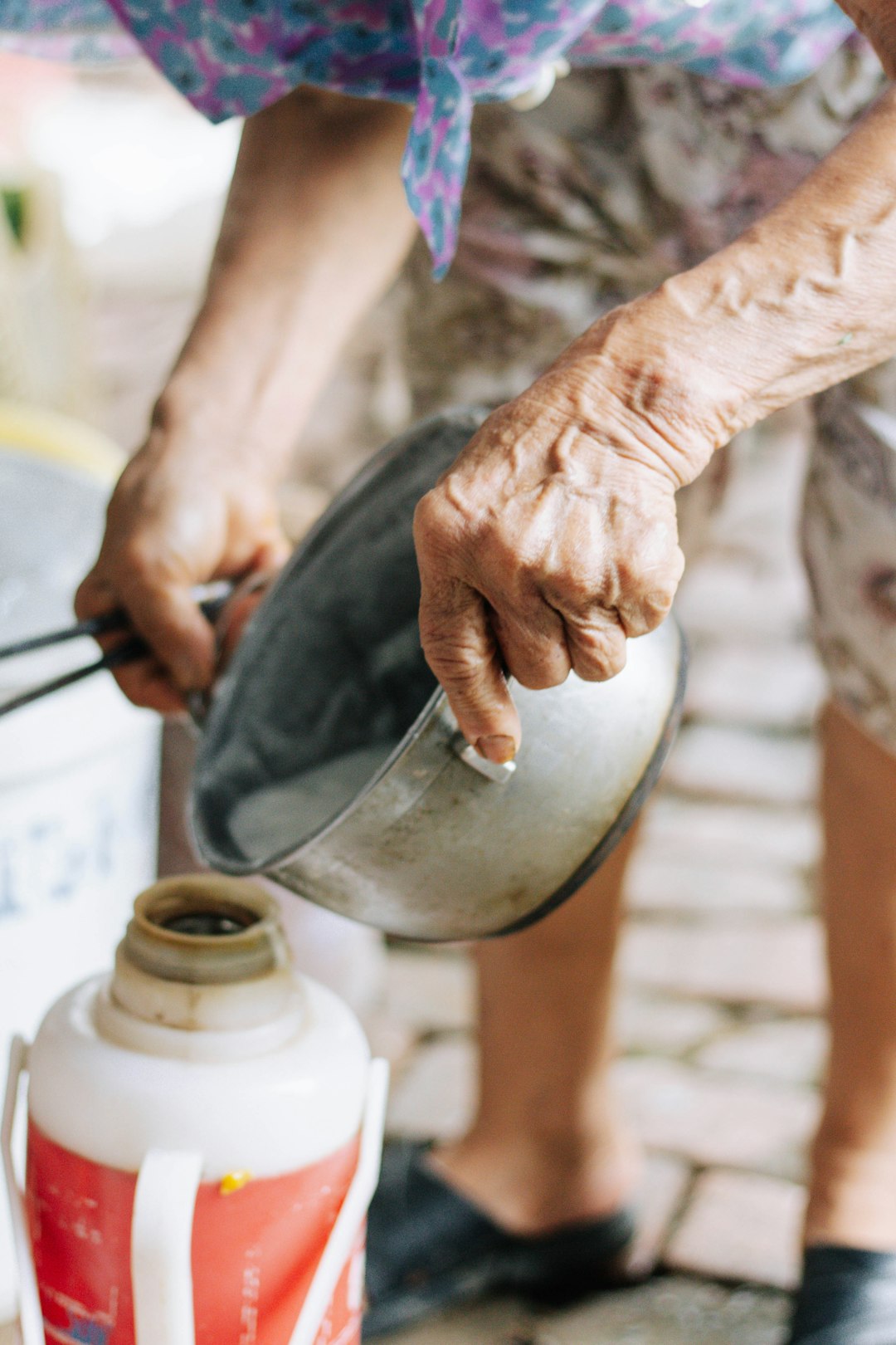 Hands pouring vinegar into limescale-filled kettle