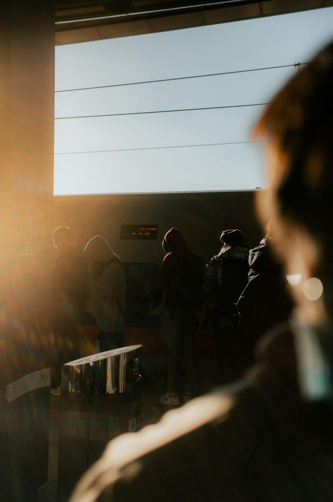 Solitary figure observing bright crowd from outside