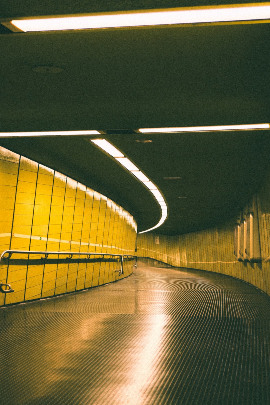 Đường hầm metro với ánh đèn vàng ấm kéo dài vào bóng tối