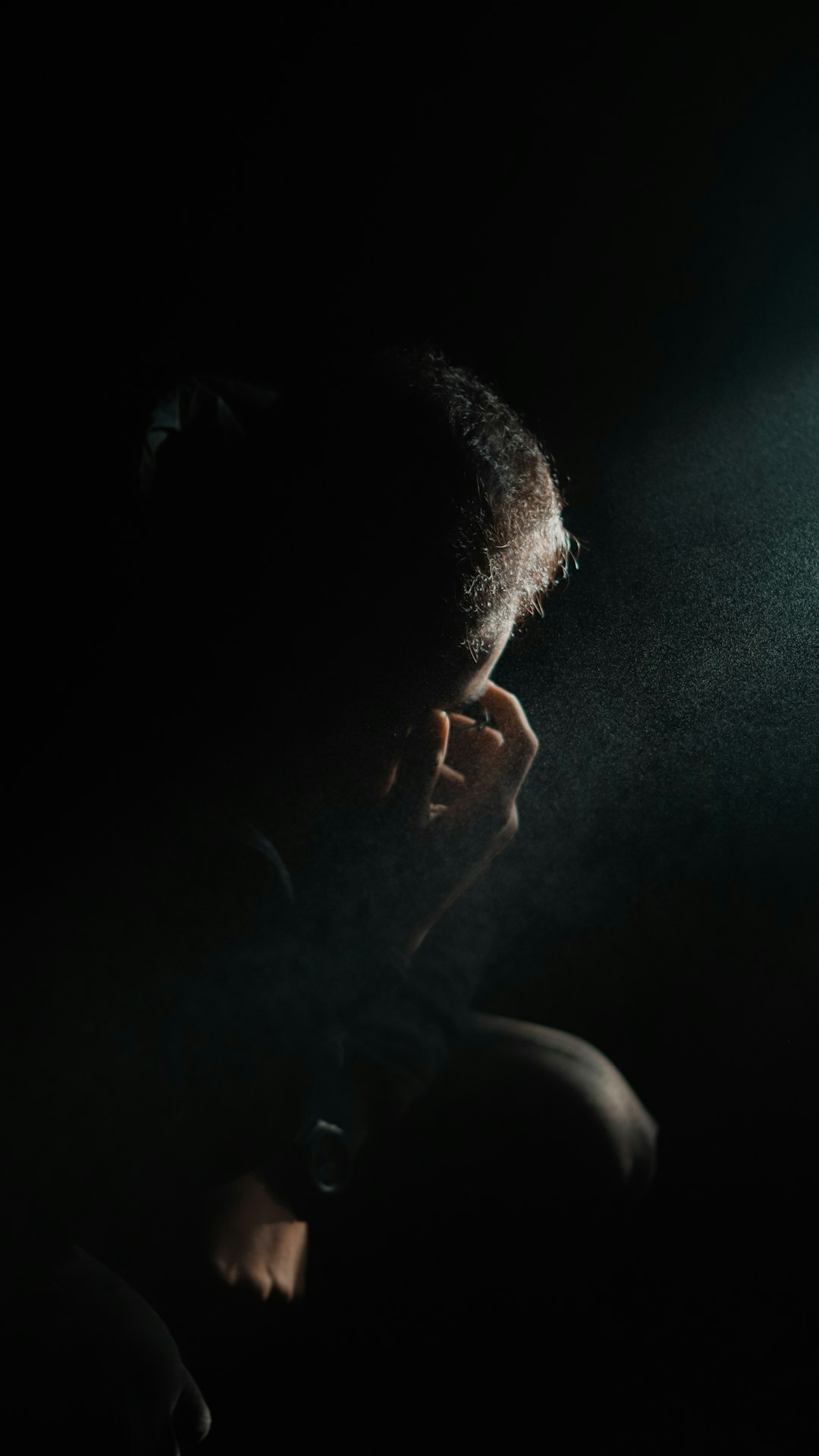 Person listening to phone call in dark room