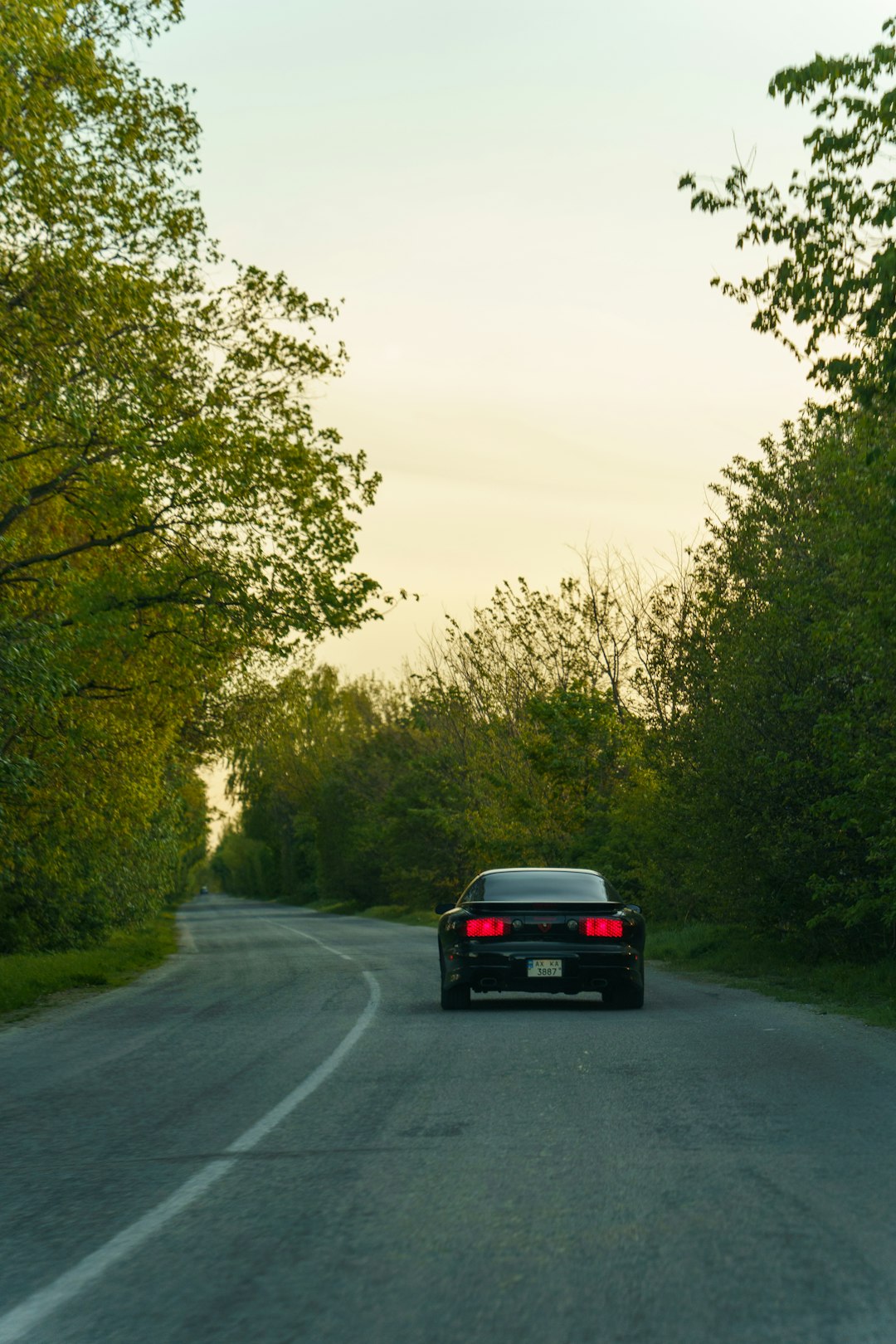 Car driving on country road at golden hour