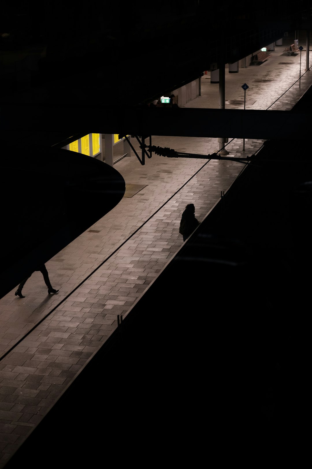 Person walking at night with glowing smartphone in hand