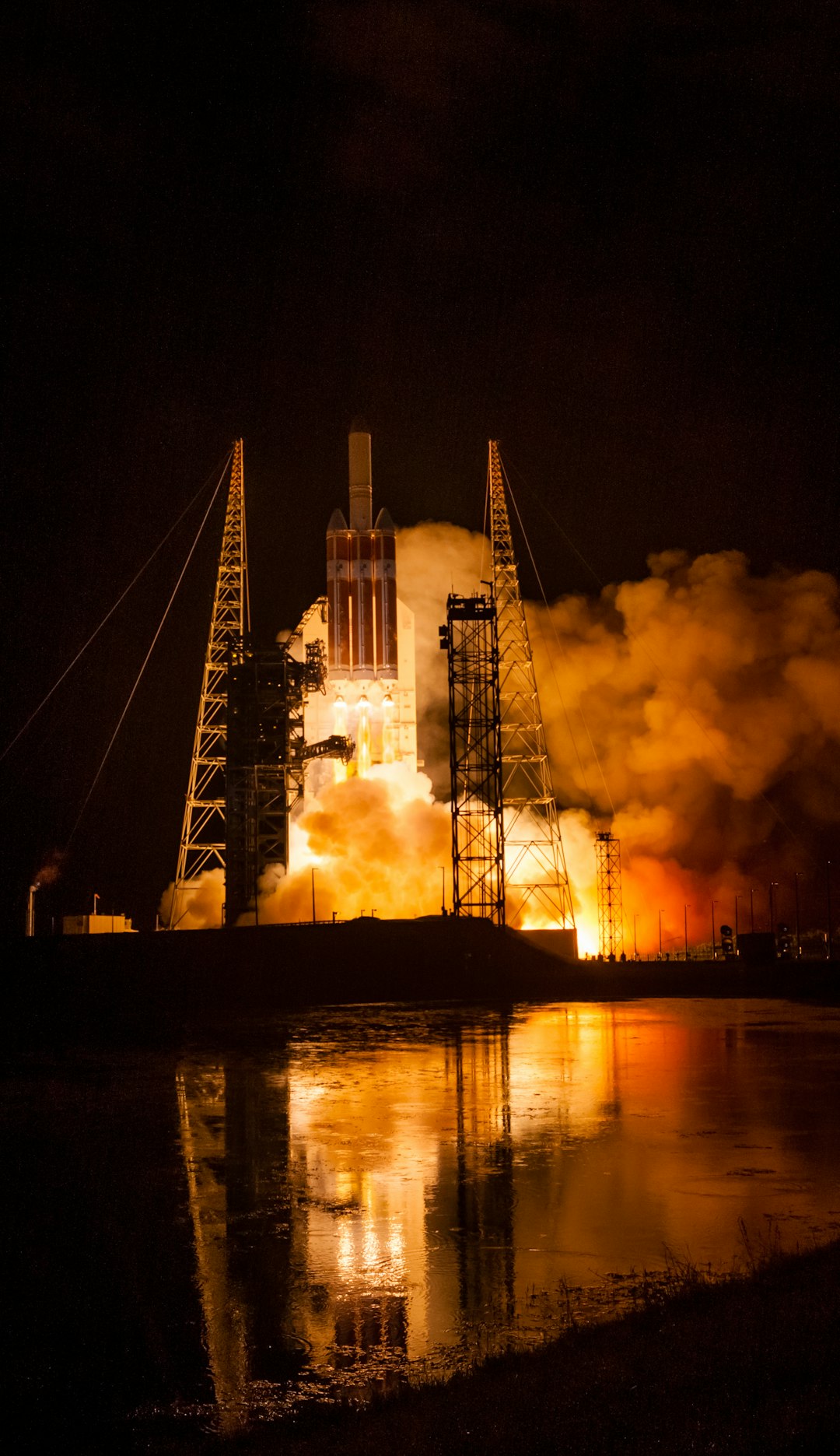 Rocket launching at night with water reflections