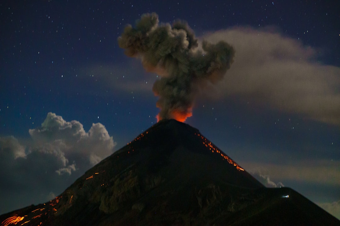 Gunung berapi aktif meletus dengan aliran lava di lereng