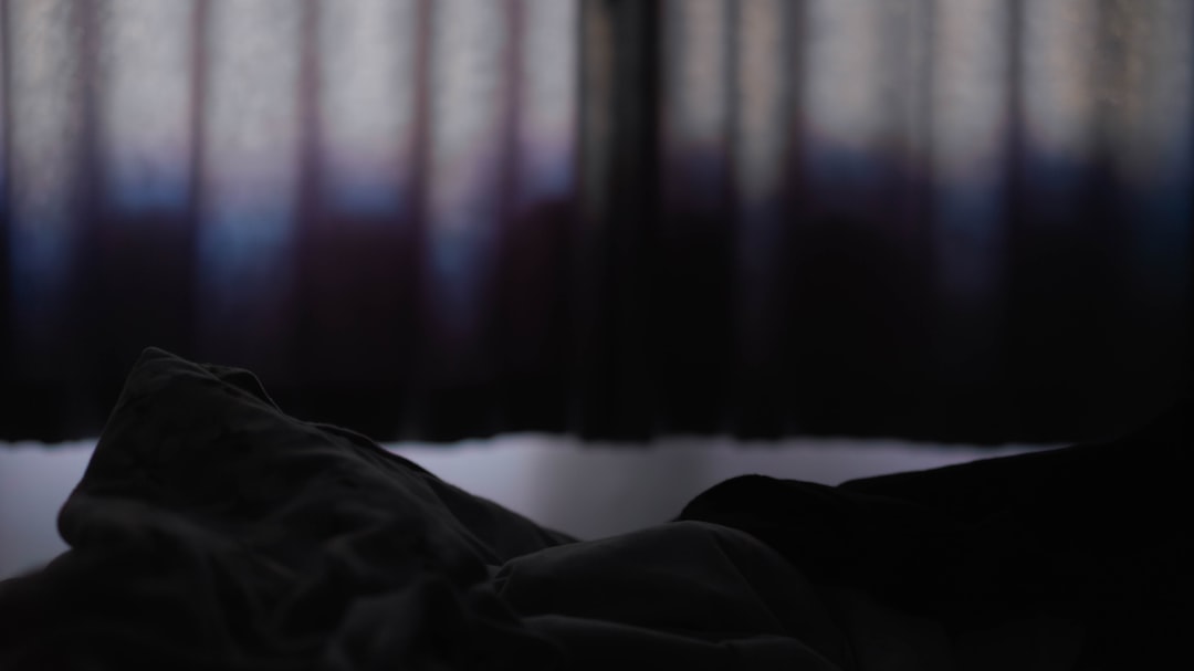 遮光カーテンの寝室で安らかに眠る人物