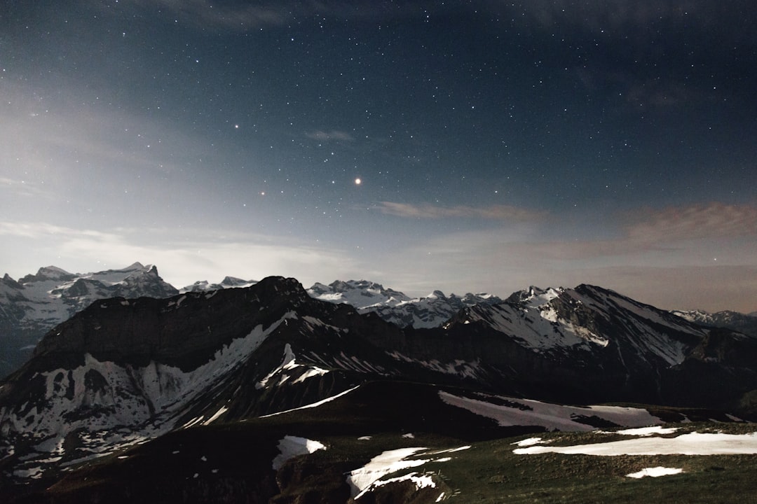 Bright planetary conjunction above mountain silhouette at night