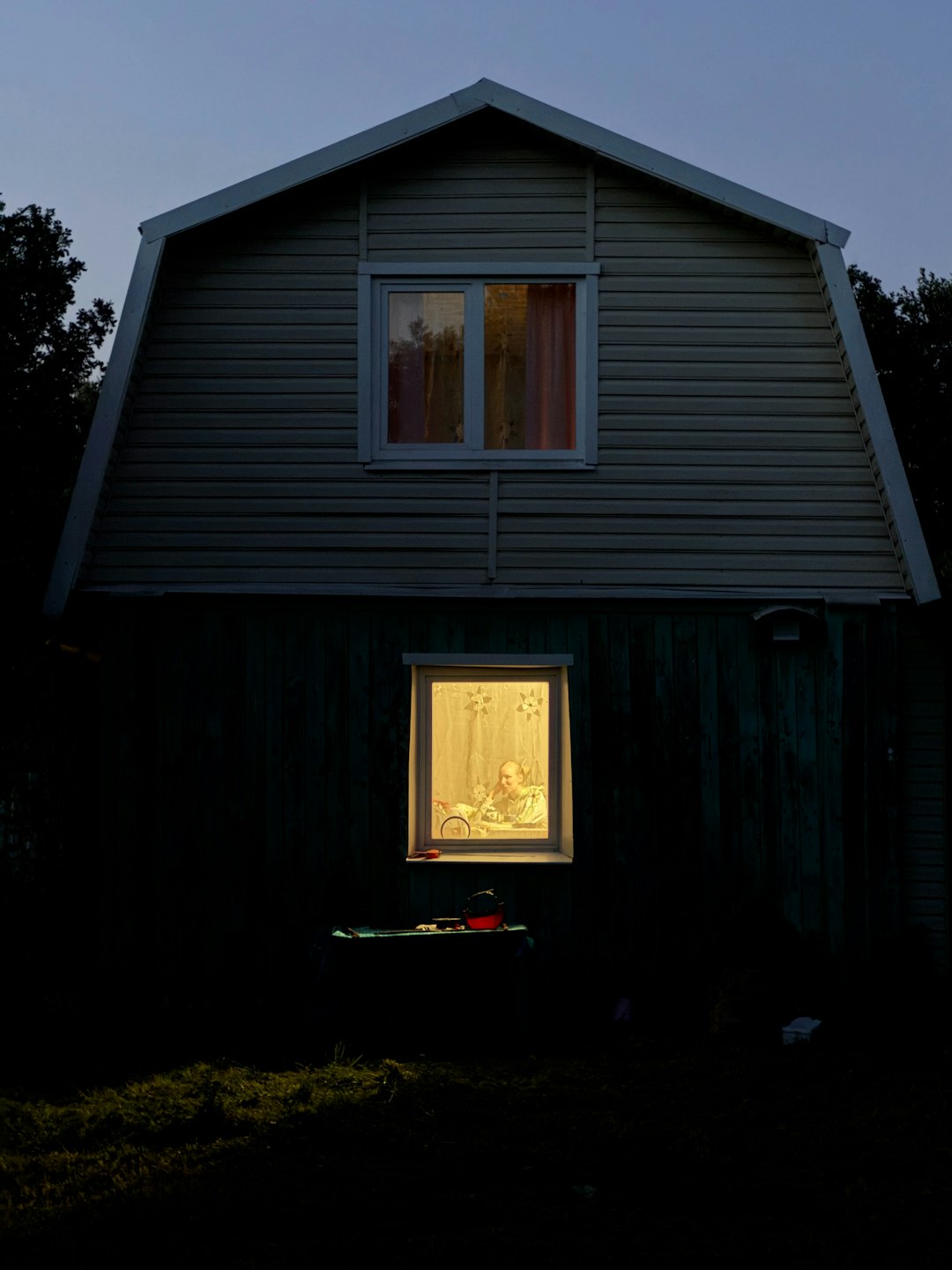 Casa prefabricada iluminada al atardecer entre árboles