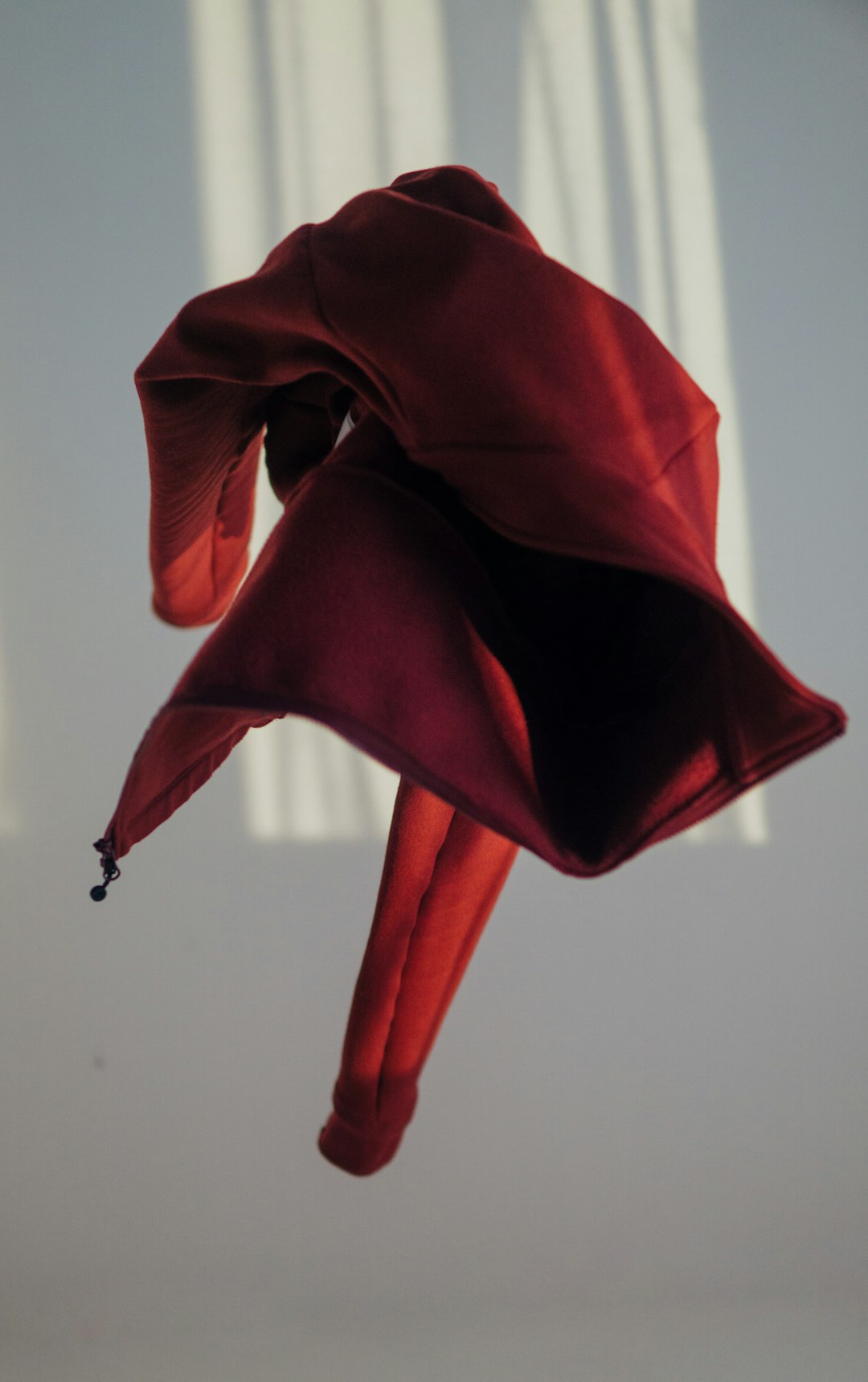 Vestido vermelho pendurado em parede branca minimalista