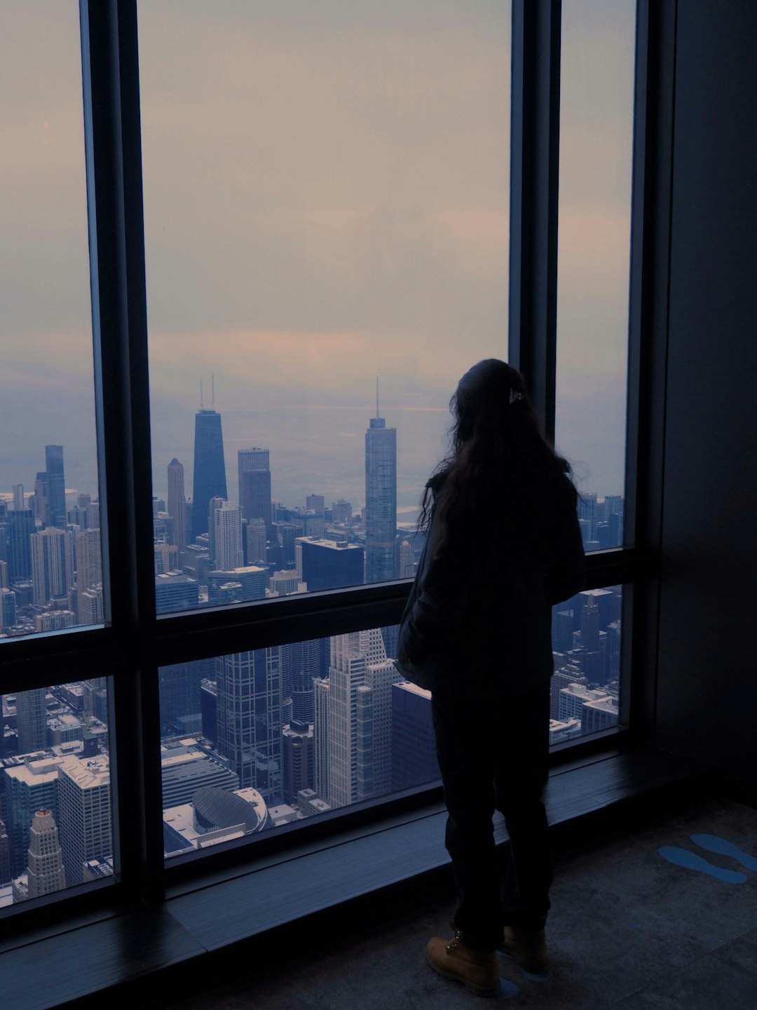 Person contemplating future career at city window