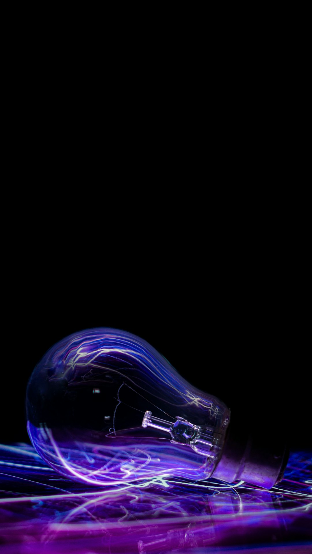 Illuminated lightbulb with circuit patterns inside, dark background