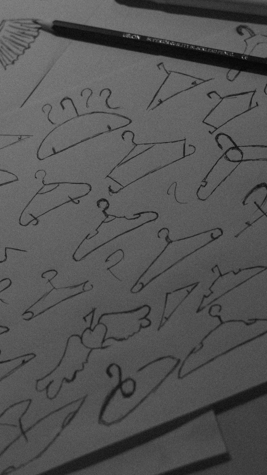 Minimalist logo sketch in pencil on cream paper
