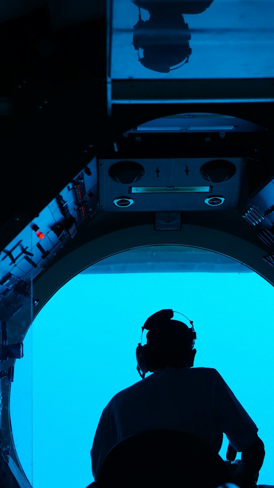 Astronaut looking at Earth through space station porthole
