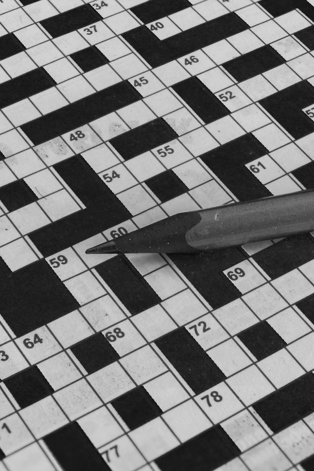 Newspaper crossword puzzle on wooden table with pencil