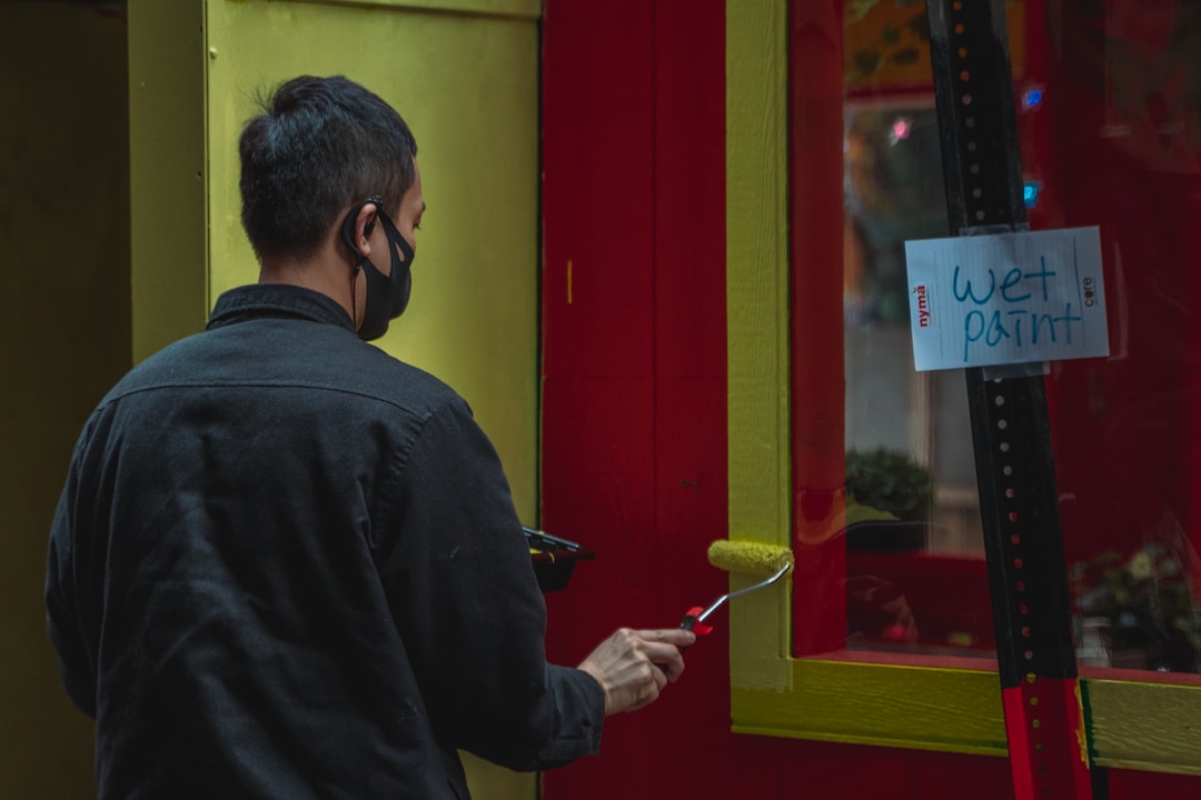 Comerciante colocando letrero con móvil al lado