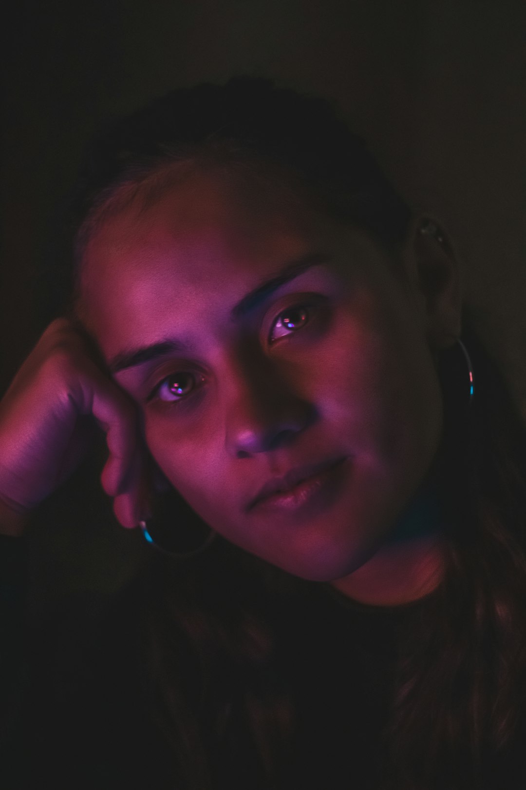 Person illuminated by phone screen in dark room