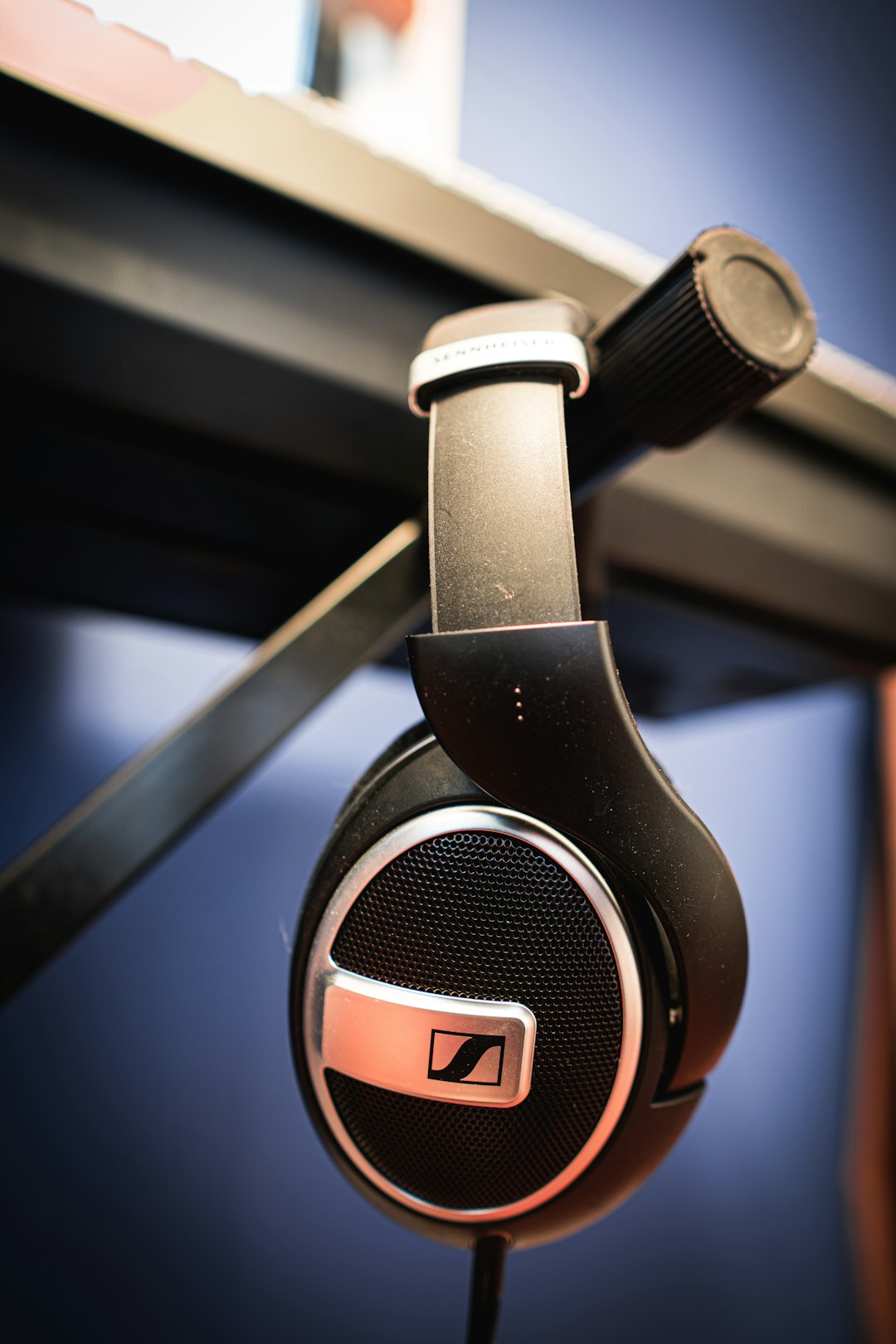Classic wired headphones hanging on wooden wall hook