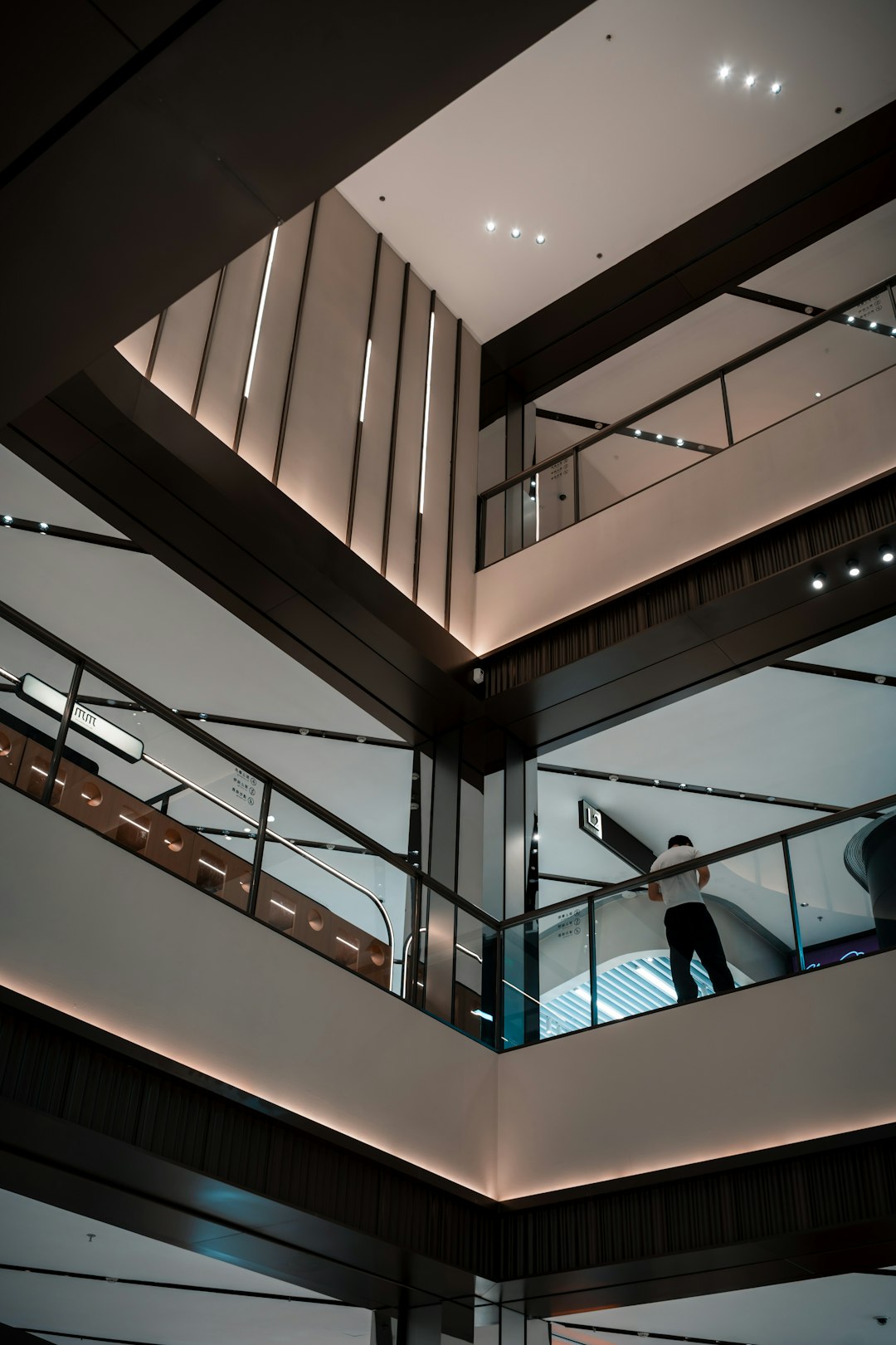 Profesional berdiri di tangga gedung modern memandang ke atas