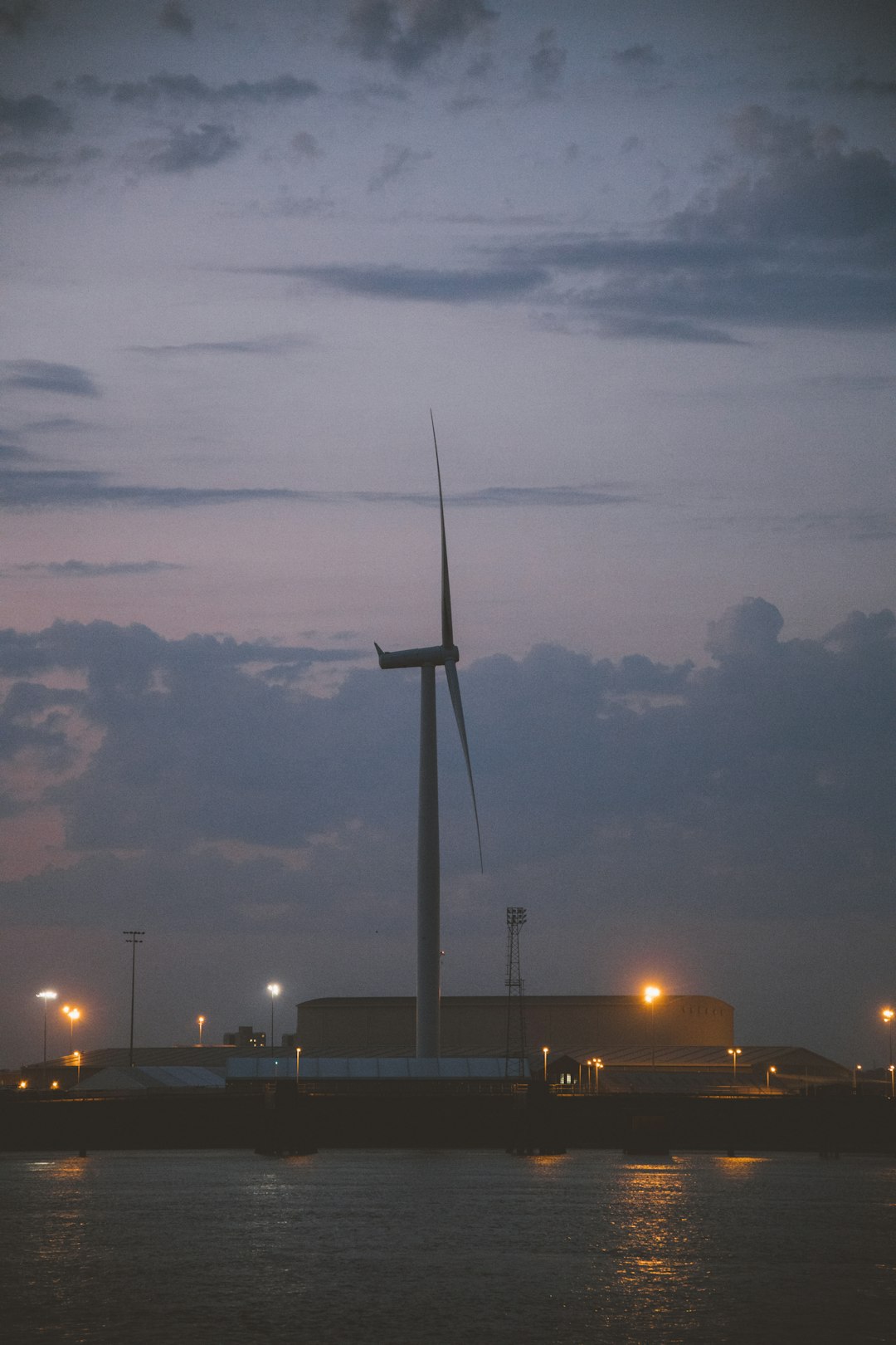 風力発電機とデータセンターの夕暮れシルエット