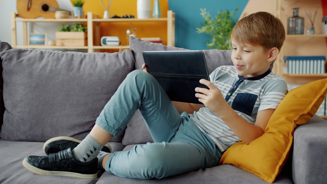 Child using tablet while parent observes at home