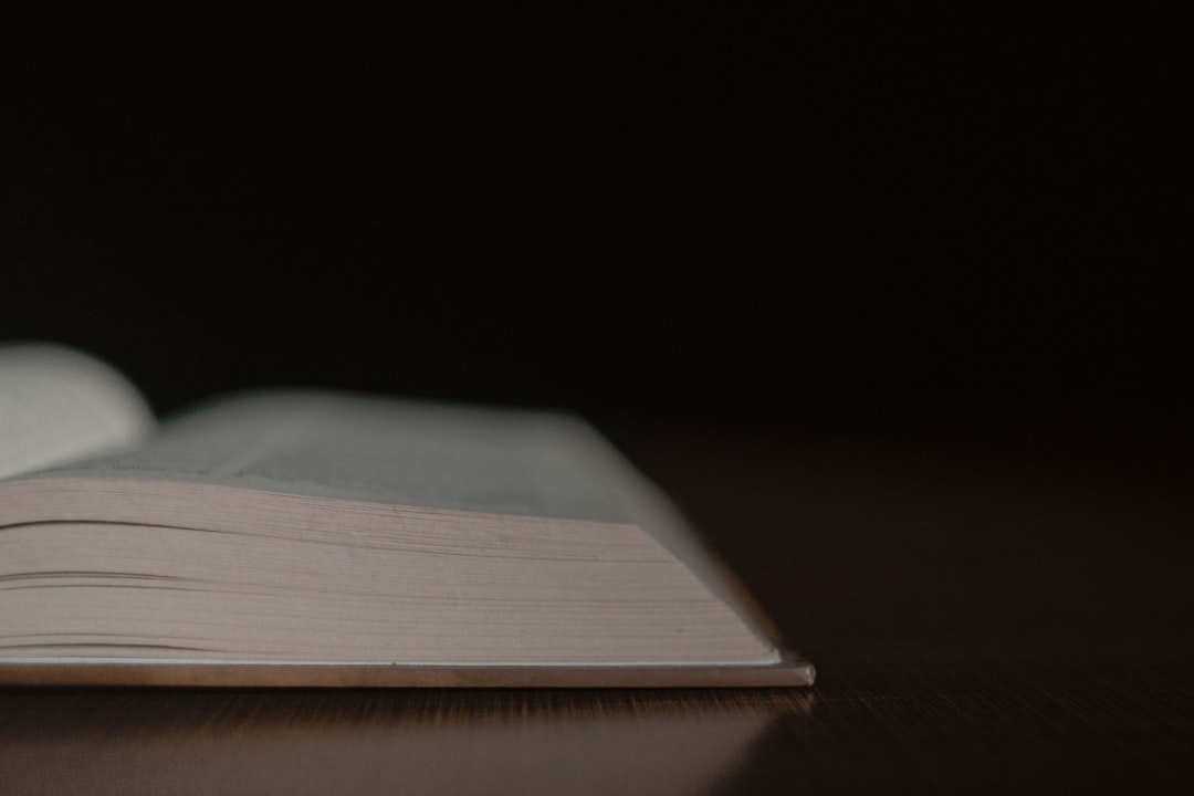 Open book with text beside a blank page by candlelight