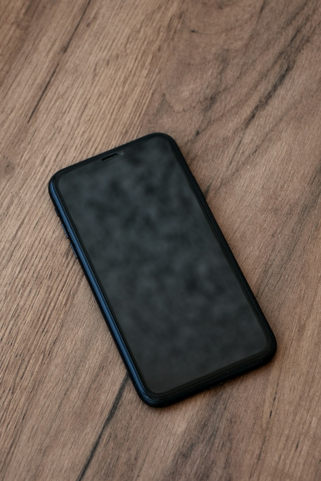 Smartphone with fresh home screen after restart on wooden surface