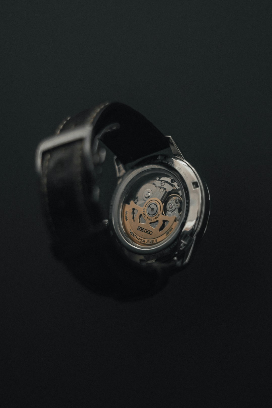 Open mechanical watch showing tourbillon cage on velvet