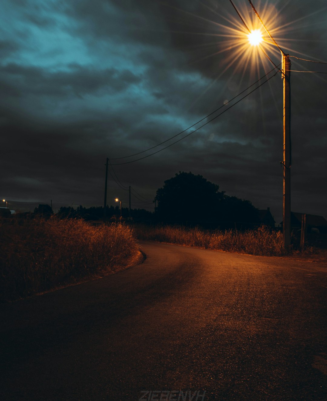 Lone fuel station glowing at night on empty rural road