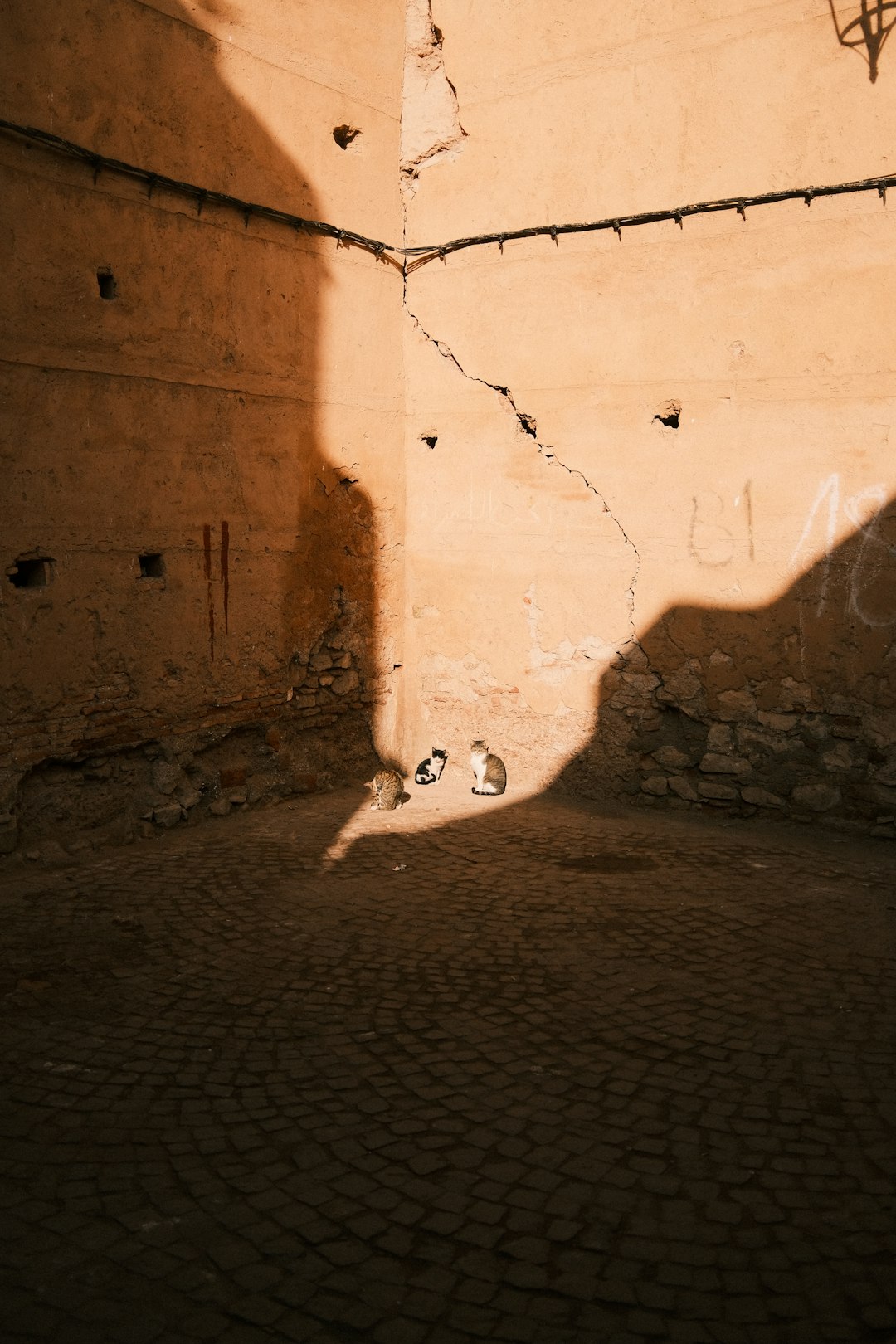 Child kicking soccer ball in alleyway at golden hour