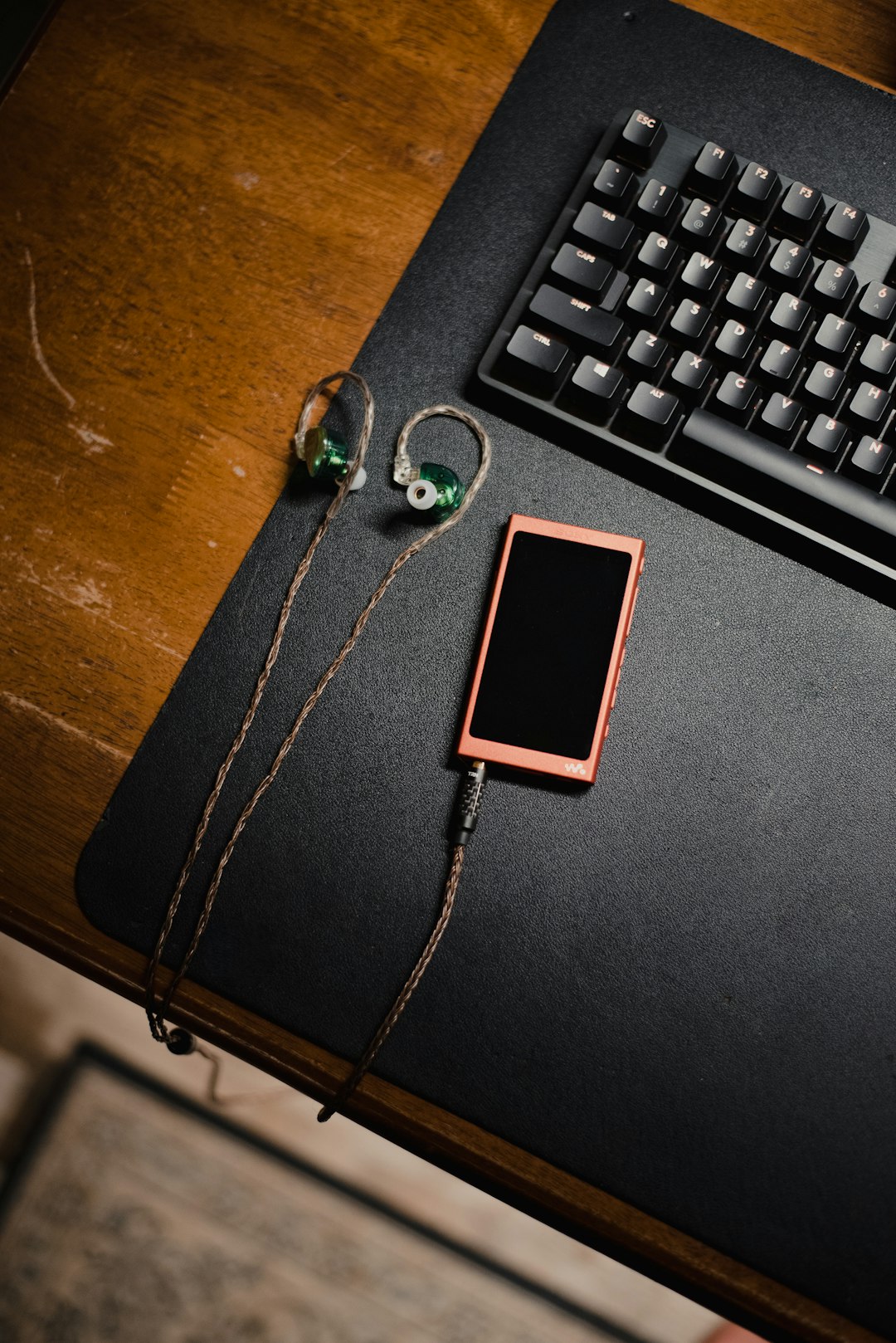 有線イヤホンとスマートフォンが並ぶデスク