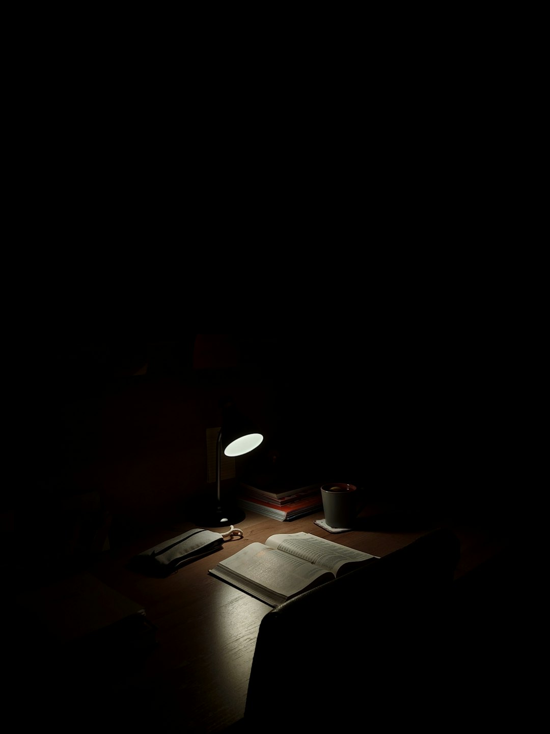 Bombilla y cuaderno con signo de interrogación, iluminación dramática