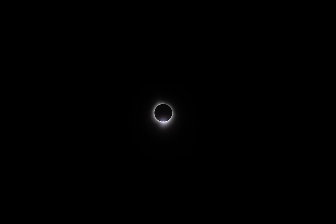Eclipse solar total con corona visible en cielo oscuro