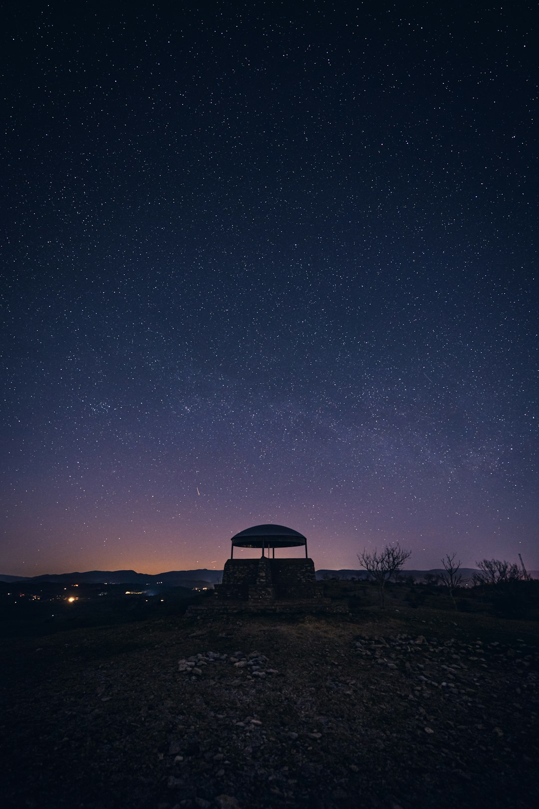 Scientist silhouetted under Milky Way at observatory