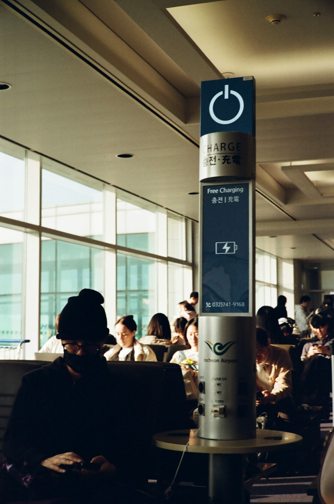 Person wearing noise-cancelling headphones in busy airport